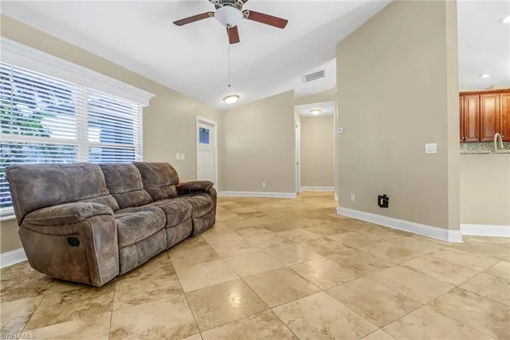 Living room featuring ceiling fan and light tile floors