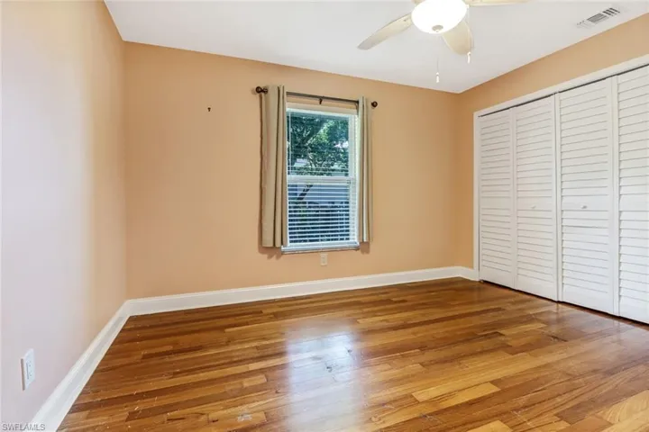 Unfurnished bedroom featuring ceiling fan, a closet, and hardwood / wood-style floors