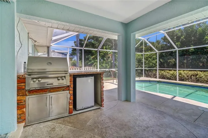 View of swimming pool with grilling area, a lanai, and a patio area