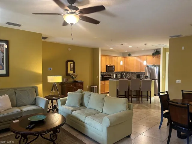 Living area featuring light tile patterned floors, a ceiling fan, and recessed lighting