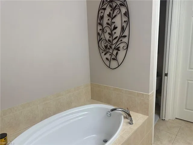 Bathroom featuring a bath and tile patterned flooring