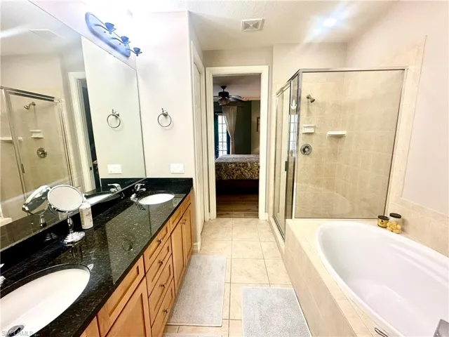 Full bath featuring double vanity and a bath