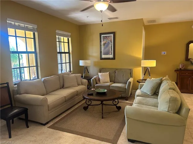 Living area with ceiling fan and light tile patterned floors
