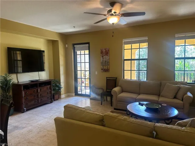 Living room with plenty of natural light, a ceiling fan, and light tile patterned floors