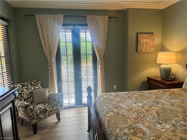 Bedroom featuring wood-look finished floors and ornamental molding  This improvement was just completed so please disregard the carpeting in some of the primary ensuite photographs.