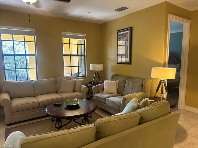 Living room featuring light tile patterned floors and a ceiling fan