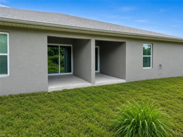 Rear exterior with a covered patio and a sliding glass door