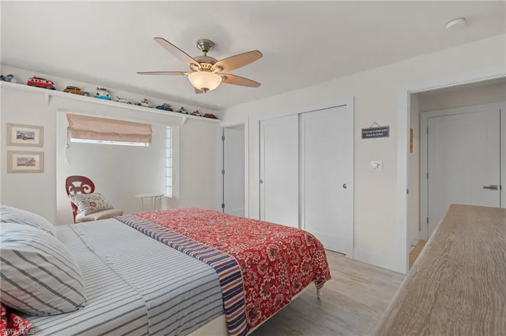 Bedroom with ceiling fan, a closet, and light wood look tile flooring