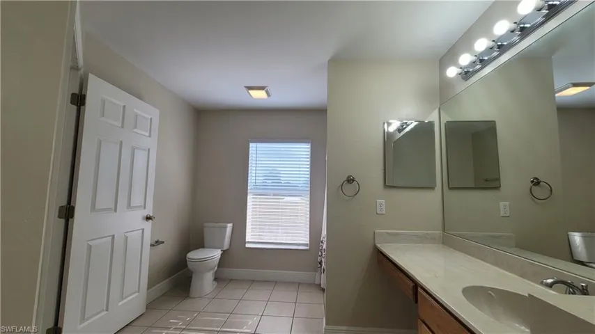 Full bath with vanity and light tile patterned floors