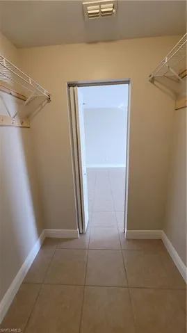 Walk in closet with light tile patterned floors
