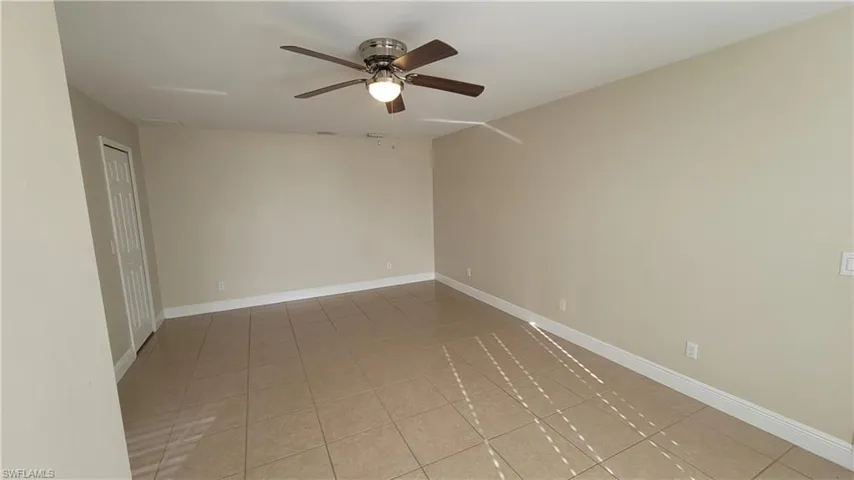 Spare room with ceiling fan and light tile patterned floors