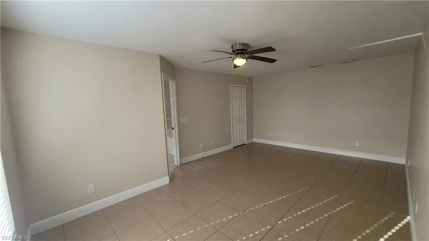 Spare room with a ceiling fan and light tile patterned floors