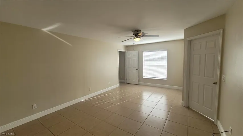 Unfurnished bedroom featuring light tile patterned floors and ceiling fan
