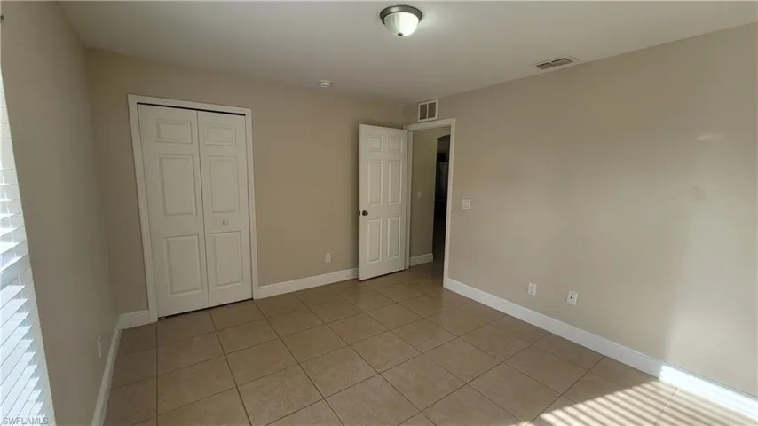 Unfurnished bedroom with light tile patterned floors and a closet