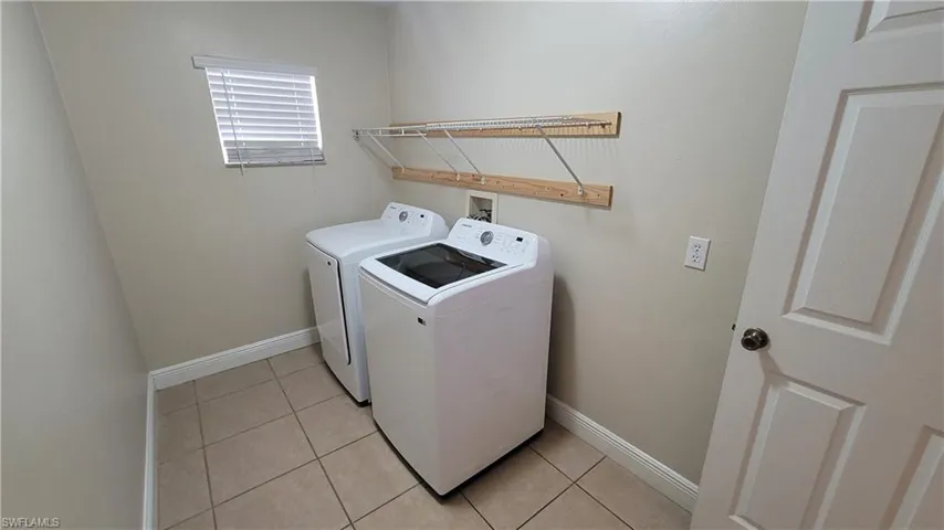 Laundry room featuring light tile patterned floors and washer and dryer