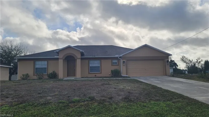 Ranch-style house featuring stucco siding, concrete driveway, a garage, roof with shingles, and a front yard