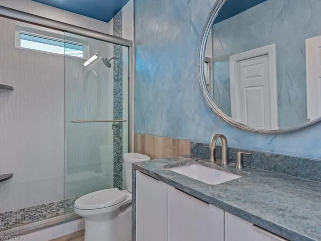Full bathroom with toilet, vanity, and a shower stall