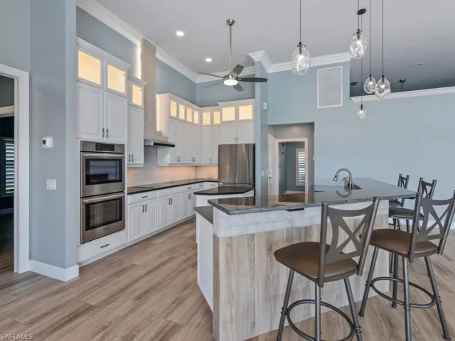 Kitchen featuring crown molding, a spacious island, a ceiling fan, stainless steel appliances, and visible vents