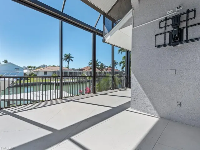 Sunroom with a residential view and a water view