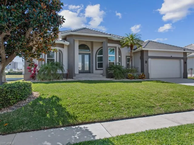 View of front of home featuring a front lawn, stucco siding, a garage, and french doors
