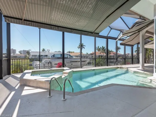 View of pool featuring a pool with connected hot tub, a lanai, and a patio