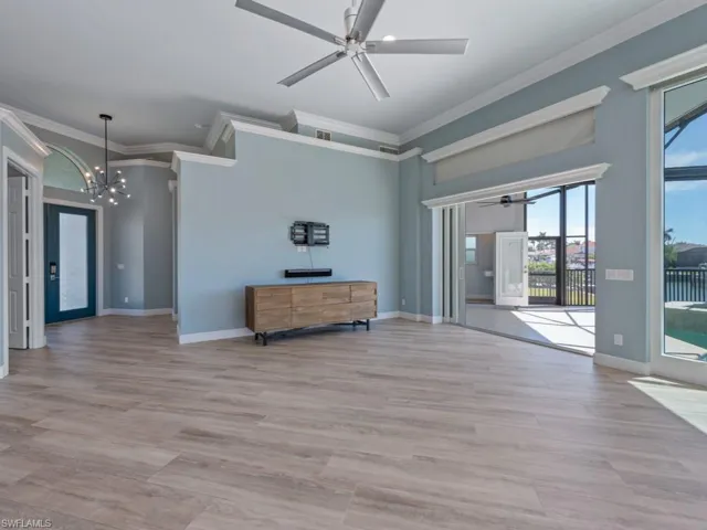 Unfurnished room with baseboards, a wealth of natural light, light wood-style flooring, and ornamental molding