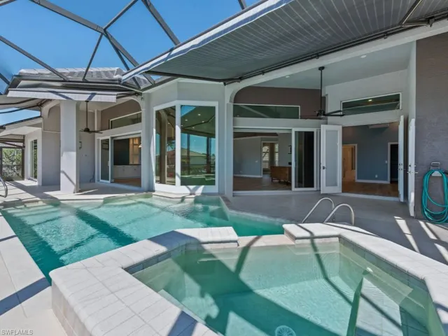 View of pool featuring a pool with connected hot tub, a lanai, and a patio