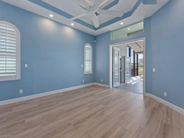 Unfurnished room with a ceiling fan, light wood-style floors, baseboards, and a wealth of natural light
