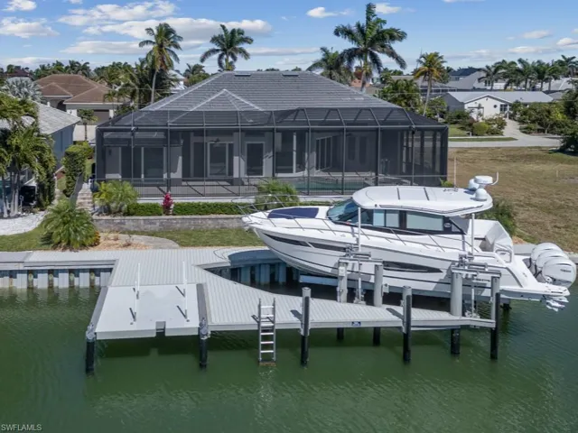 Dock area with glass enclosure, boat lift, and a water view