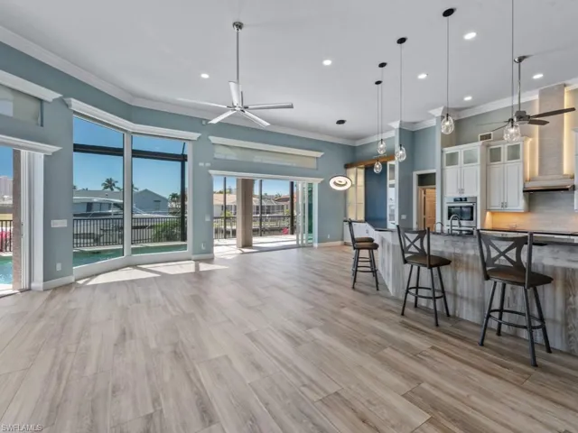 Kitchen featuring open floor plan, ceiling fan, white cabinets, and oven