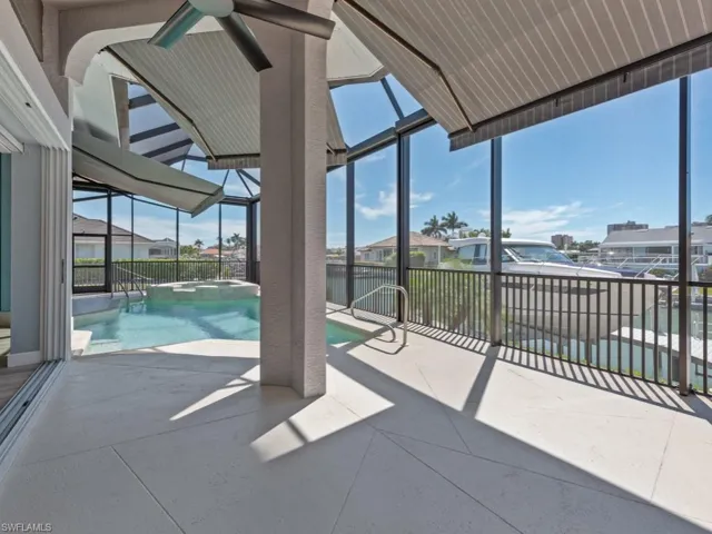 View of patio with a pool with connected hot tub, a lanai, and a residential view