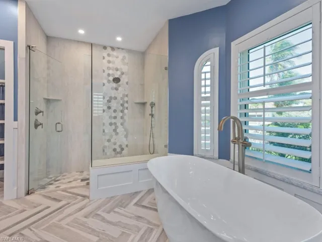 Bathroom featuring a soaking tub, a sink, recessed lighting, and a shower stall