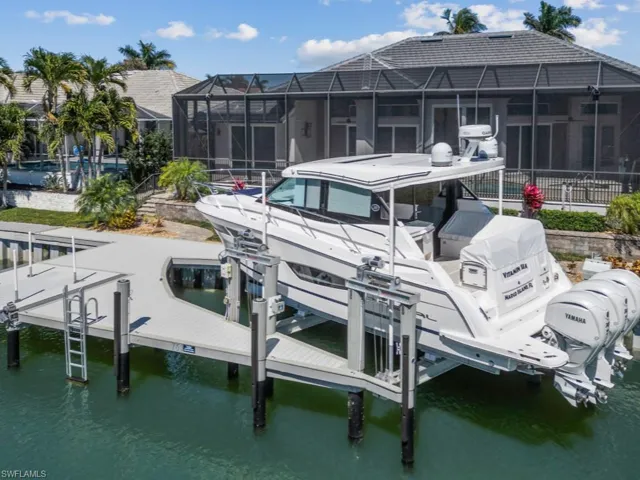 Dock area featuring a water view, glass enclosure, and boat lift