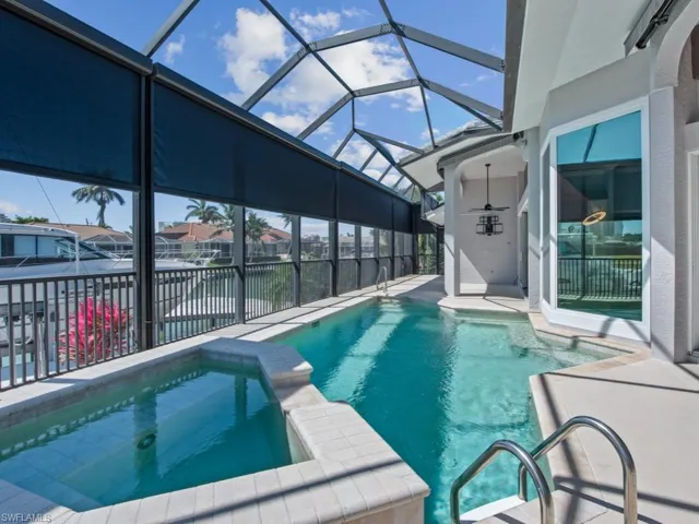 View of swimming pool with a pool with connected hot tub, a lanai, and a patio