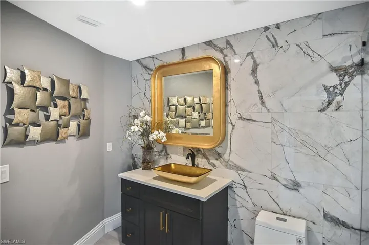 Bathroom with vanity, tile walls, tasteful backsplash, and toilet
