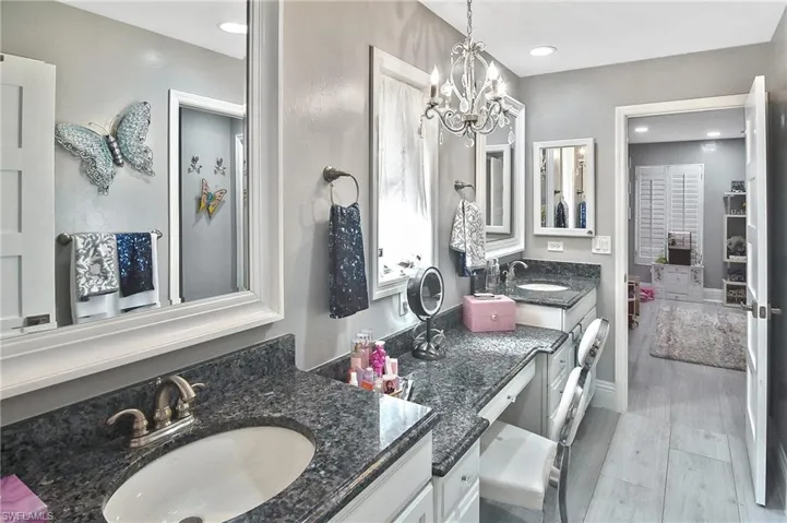 Bathroom with vanity, a notable chandelier, and hardwood / wood-style floors