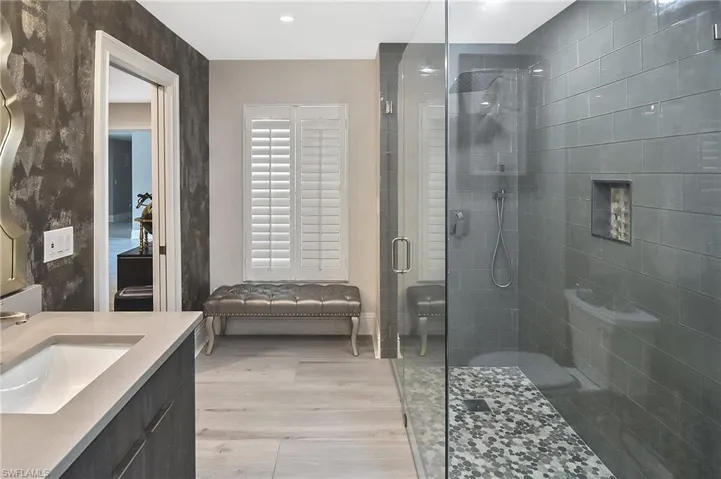 Bathroom featuring vanity, a shower with door, and wood-type flooring