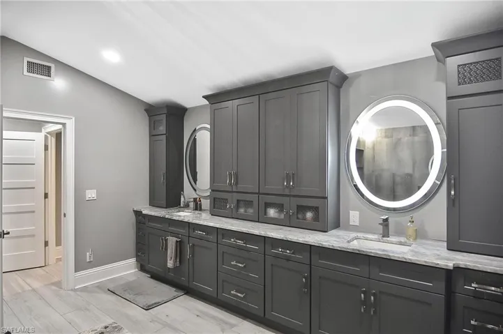 Bathroom with lofted ceiling, hardwood / wood-style floors, and double sink vanity