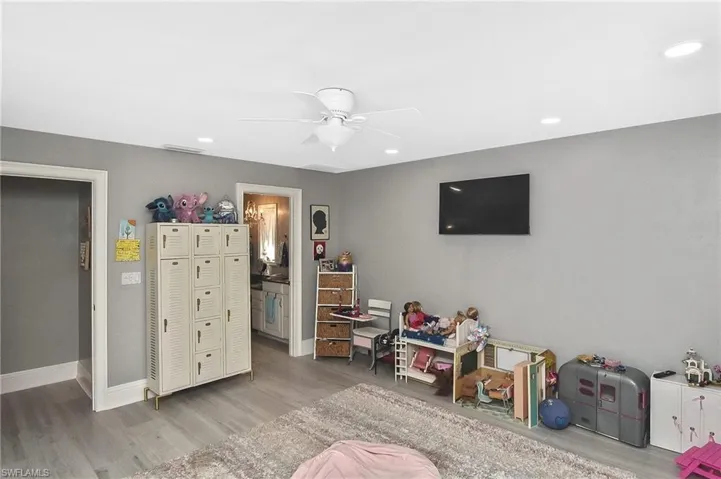 Playroom with ceiling fan and light hardwood / wood-style flooring