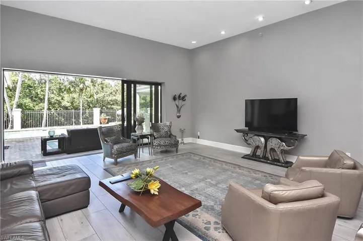 Living room featuring a towering ceiling, light hardwood / wood-style flooring, and a wealth of natural light