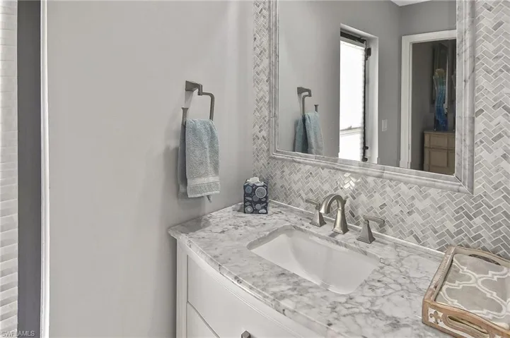 Bathroom with vanity and decorative backsplash