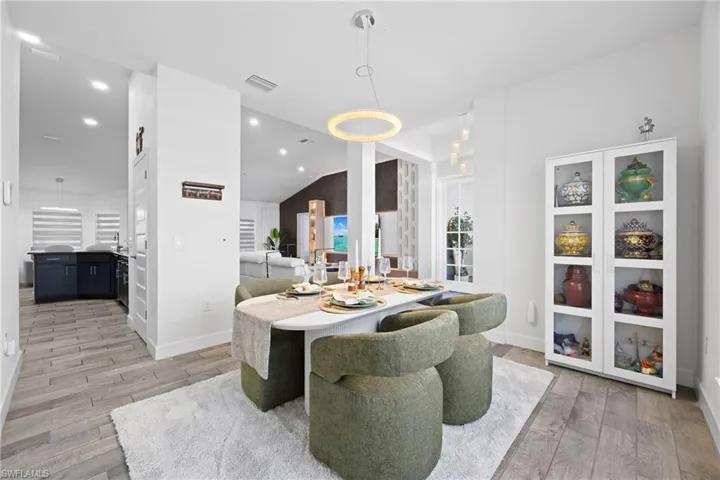Dining room with light wood-style floors and recessed lighting