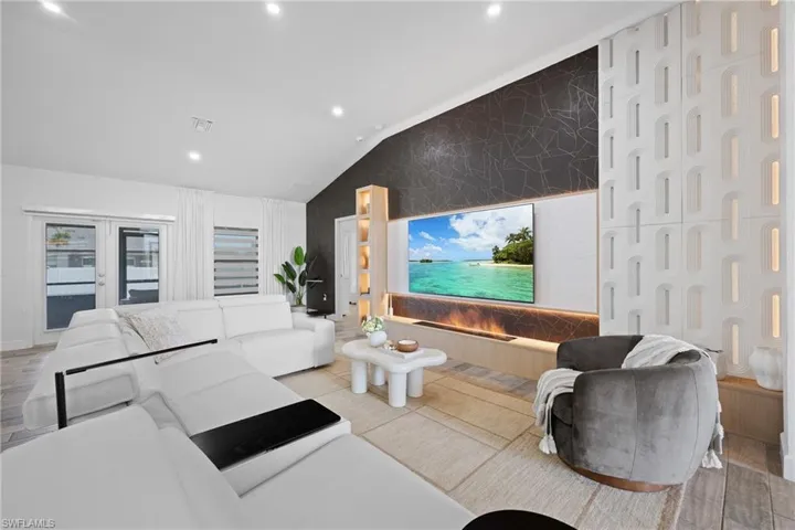 Living area featuring recessed lighting, light wood-style flooring, and vaulted ceiling