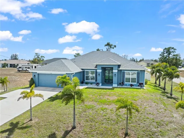 Single story home featuring stucco siding, roof with shingles, an attached garage, concrete driveway, and a front yard