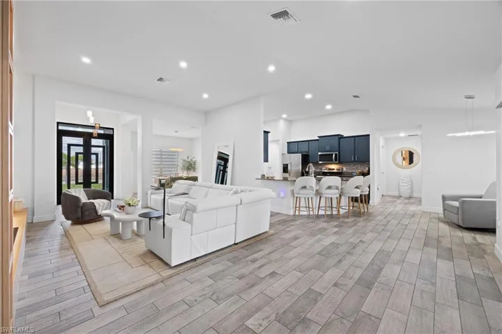 Living room with wood finish floors, recessed lighting, and lofted ceiling