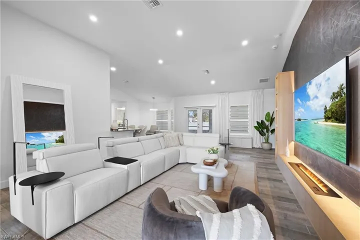 Living room featuring vaulted ceiling, light wood-style floors, and recessed lighting