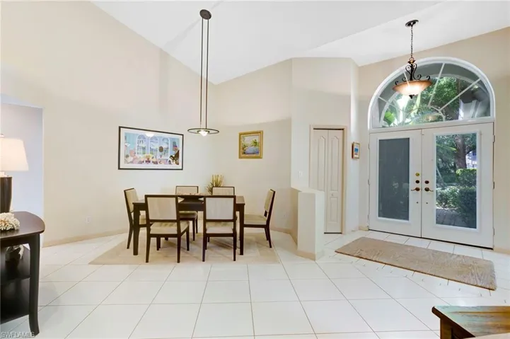 Dining space featuring an abundance of natural light, tile floors, and vaulted ceiling