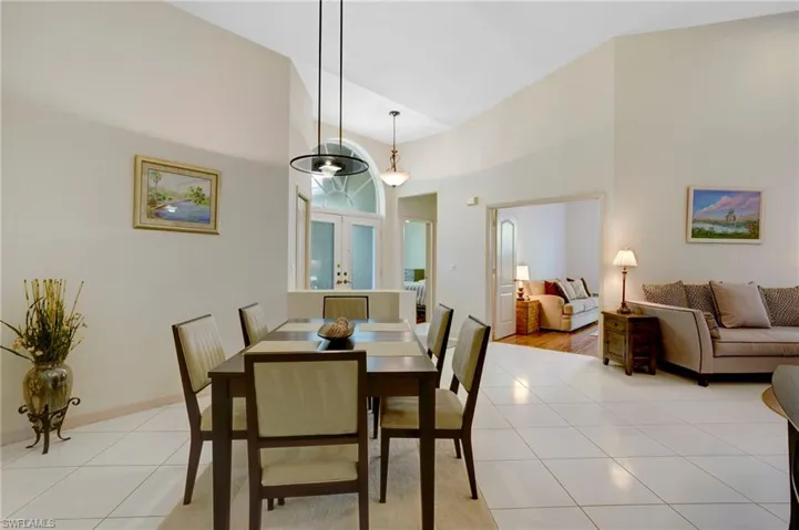 Dining space featuring an abundance of natural light, tile floors, and vaulted ceiling