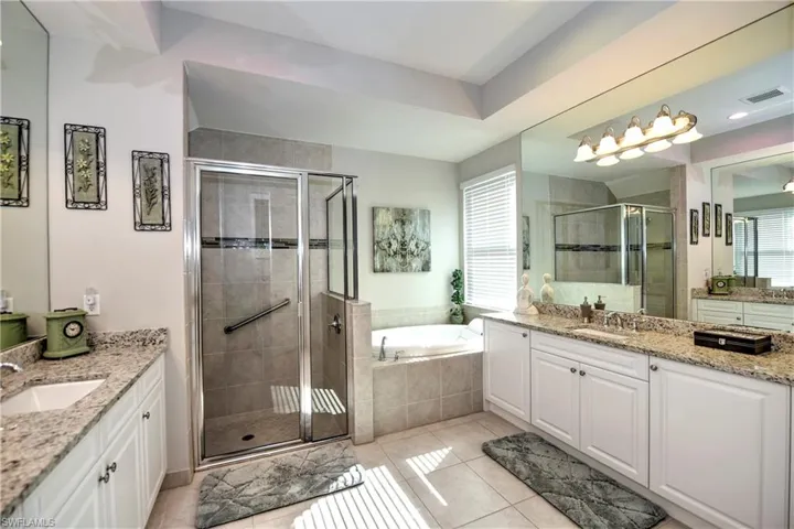 Ensuite primary Bathroom featuring separate tub and shower