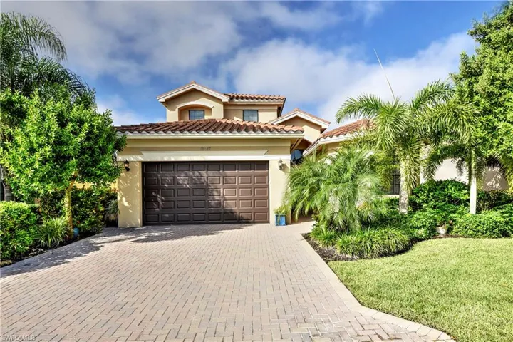 Mediterranean / spanish-style house with a garage and a front lawn